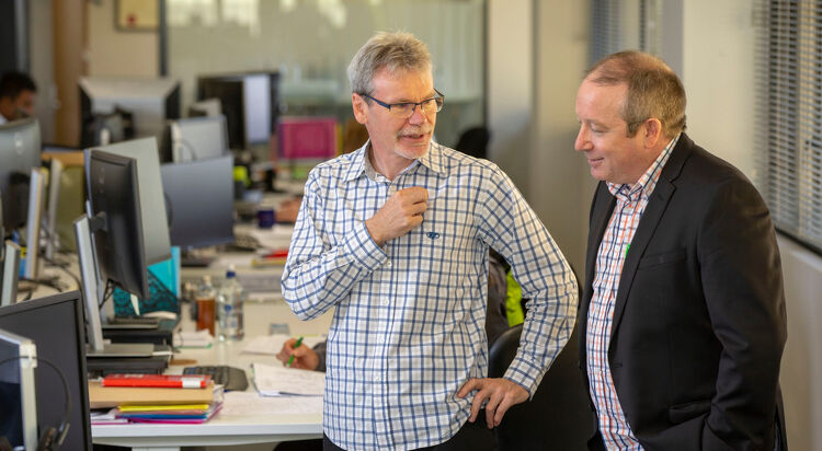 Two colleagues talking in an open-plan office